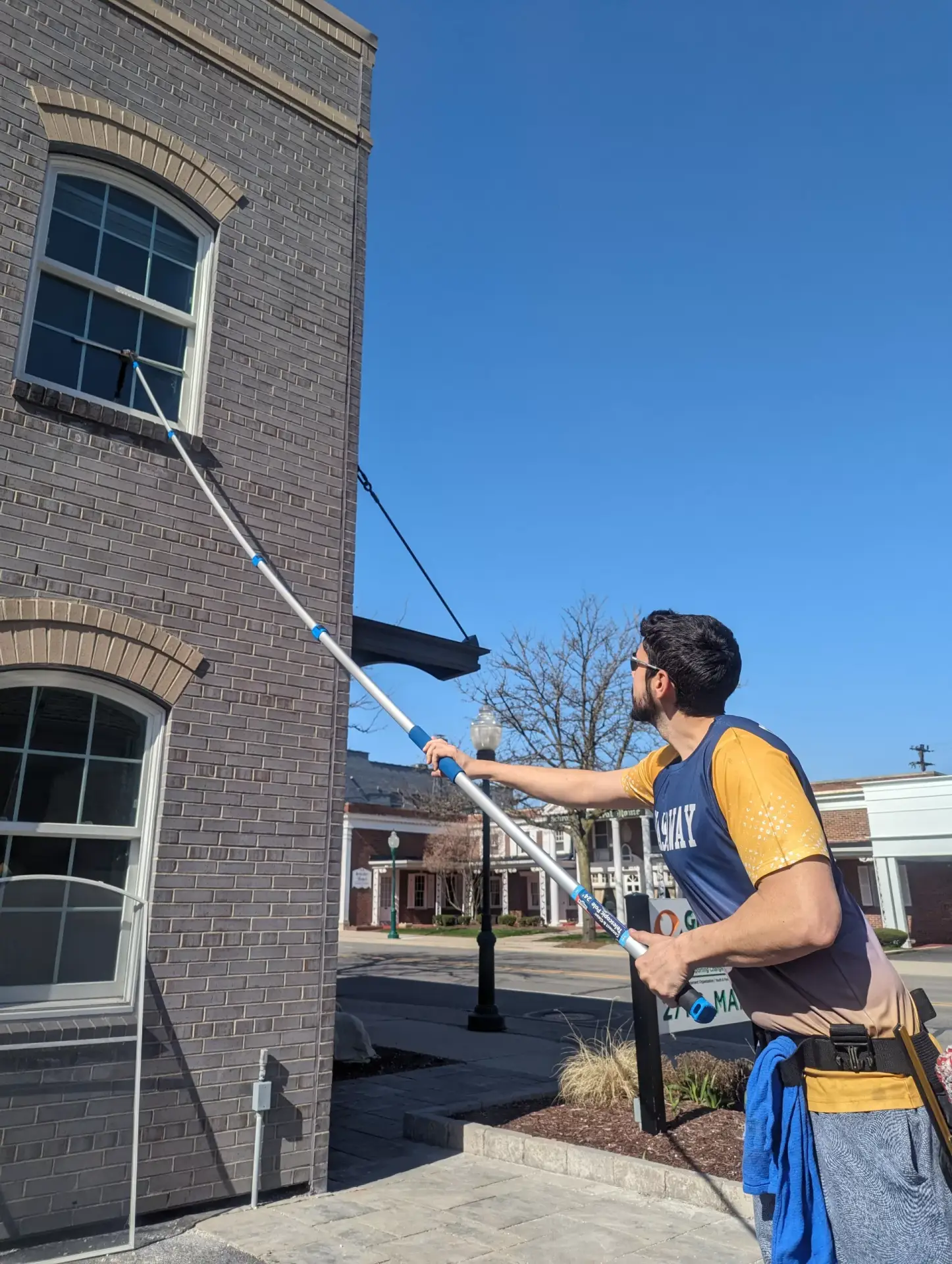 WashAway technician cleaning an upper commercial window